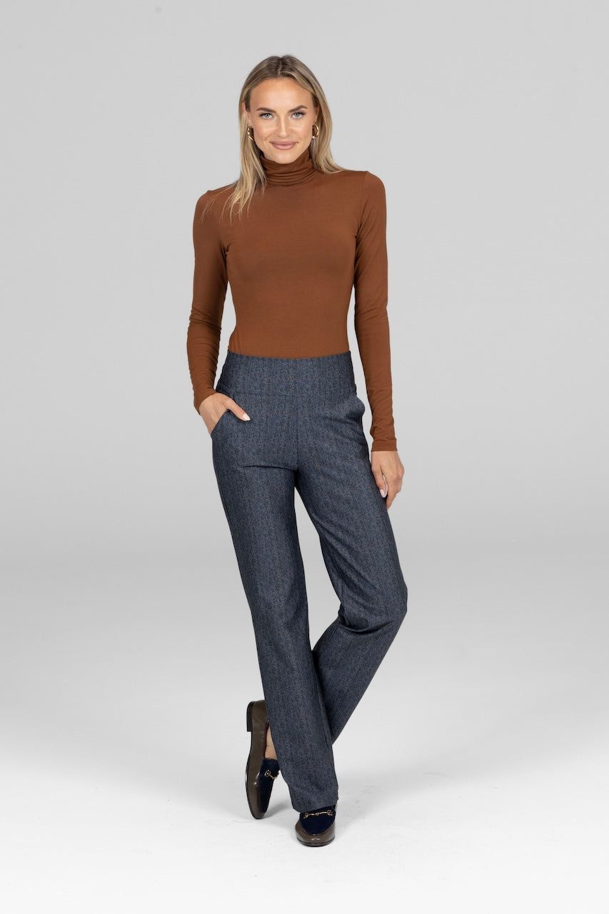 Model in bronze Grace Turtleneck, styled with a pair of high waisted pants for a modern, sophisticated outfit.