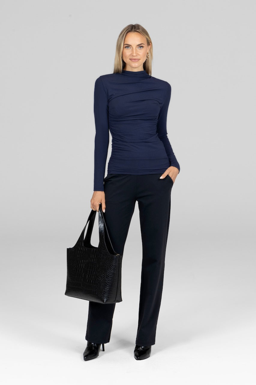 Model in marine navy Luxe Draped Long Sleeve, styled with a fitted pant and heels for a refined, evening outfit.